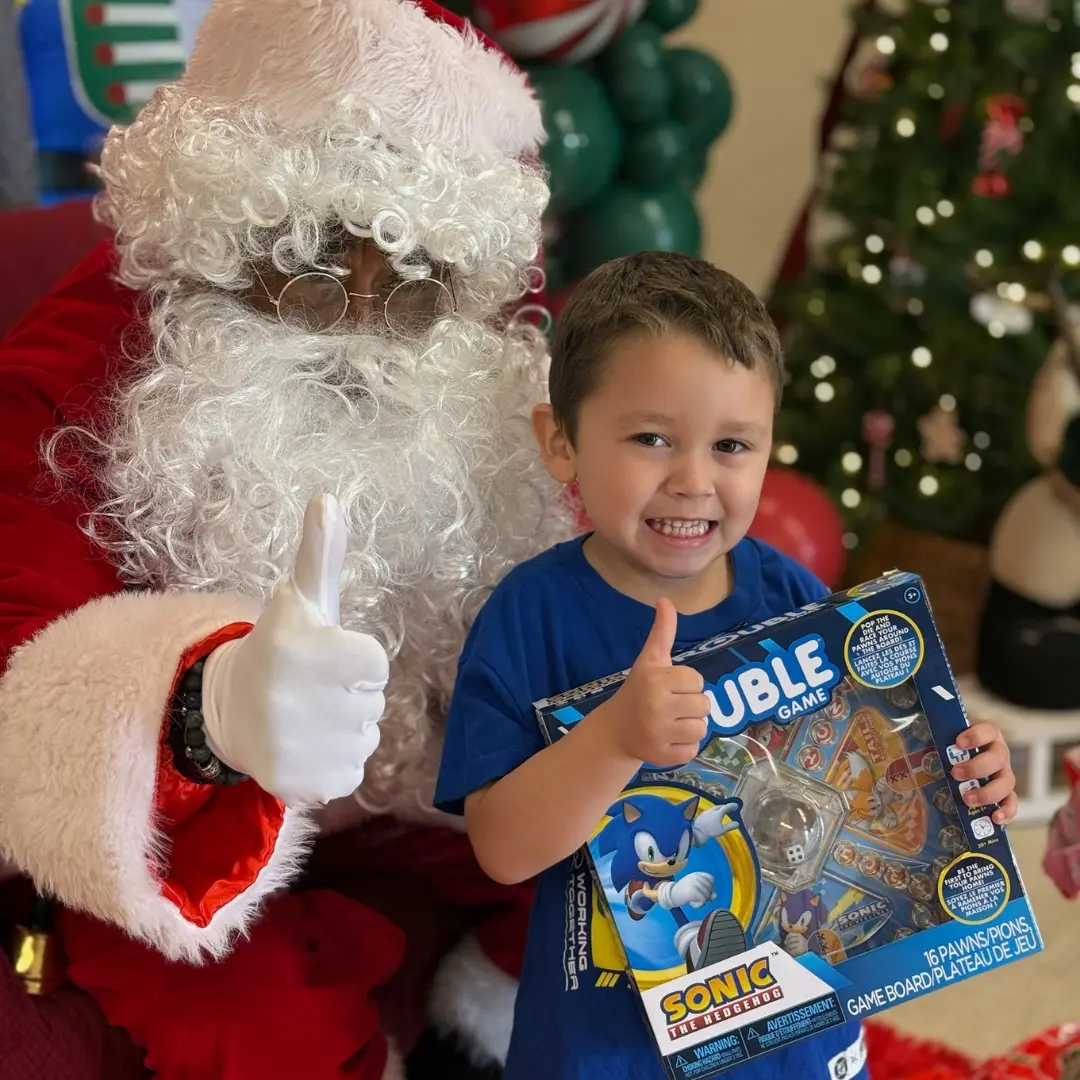 Young boy holding up his new holiday gift