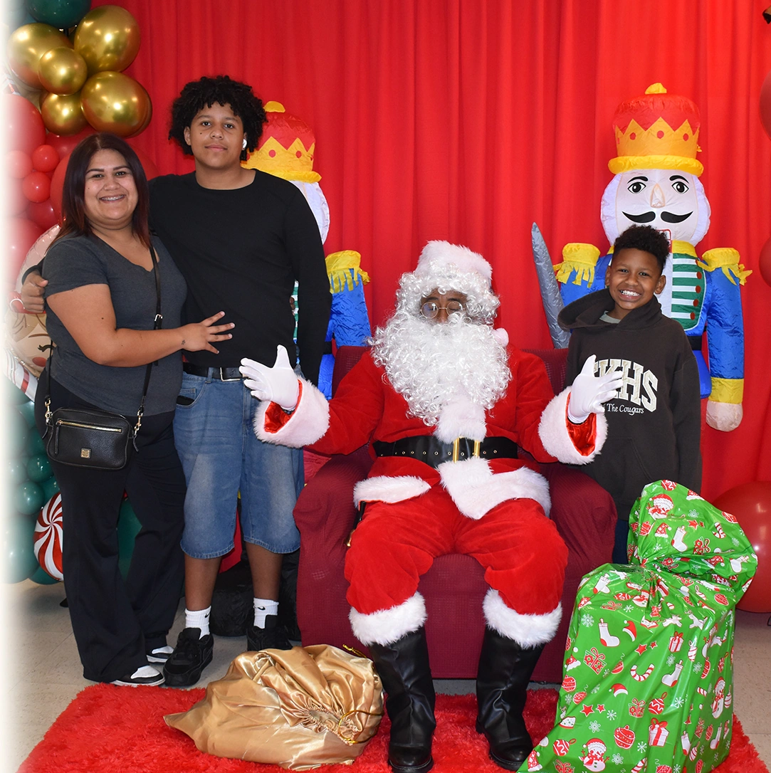 Children and teens visiting Santa at the El Centro de Amistad holiday celebration